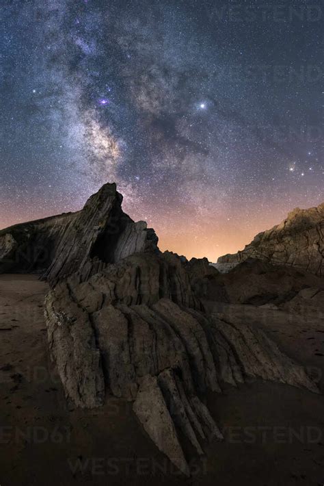 From Below Of Rough Cliff Peak Under Milky Way Colorful Blue Night Sky