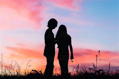 Boy And Girl Silhouette Standing Close And Talking To Each Other By