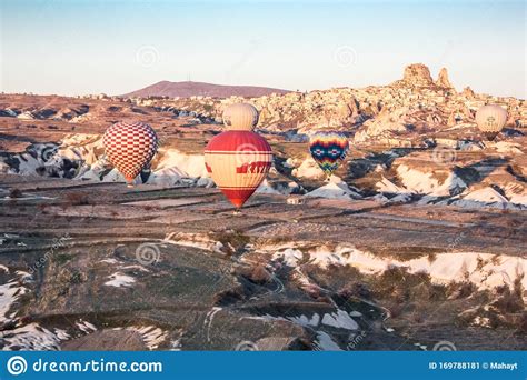 Hot Air Balloons In The Sky During Sunrise Flying Over Colourful Rock