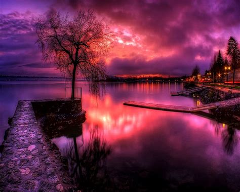 The Sky Is Purple And Red As It Reflects In The Water At Night With