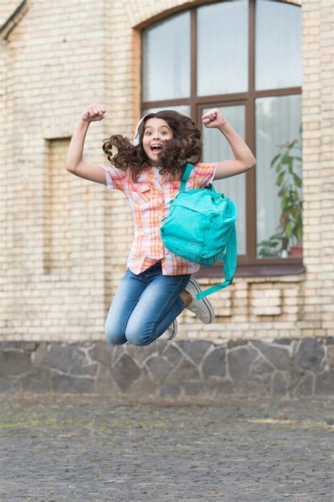 Happy Energetic Kid Jump With School Bag In Casual Style In Schoolyard