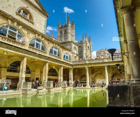 The Great Bath Of The Roman Baths With Bath Abbey Towering Above The