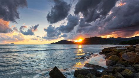 Download Wallpaper 2560x1440 Sunset Rays Coast Sea Stones