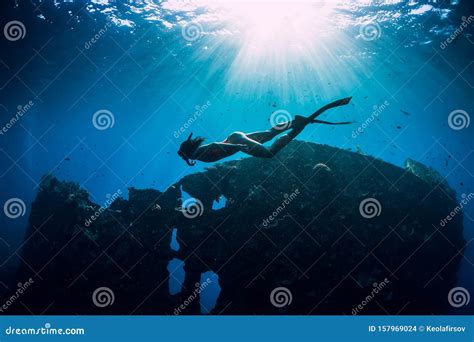 Freediver Girl In Pink Swimwear With Fins Swimming Underwater At Wreck
