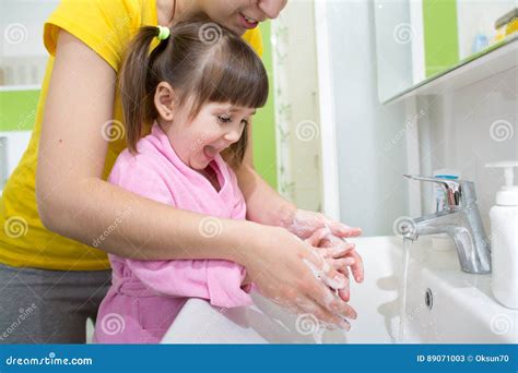 Child Girl And Mother Washing Hands With Soap In Bathroom Stock Image