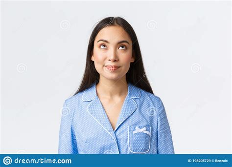 Close Up Shot Of Intrigued Asian Girl In Blue Pajama Smiling And