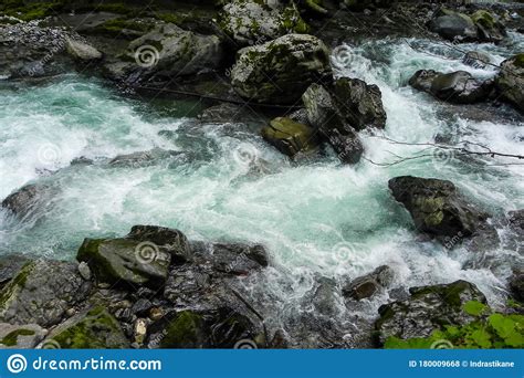 A Fast Small River Flows Through Rocks And Stones Stock Photo Image