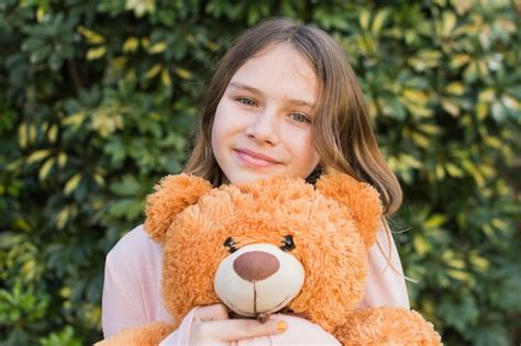 Free Photo Portrait Of A Smiling Girl Holding Teddy Bear At Outdoors