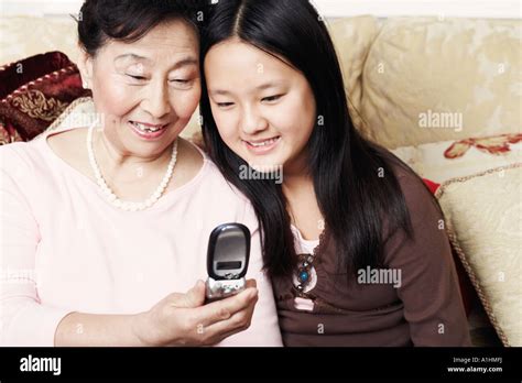 Close Up Of A Girl And Her Grandmother Looking At A Mobile Phone Stock