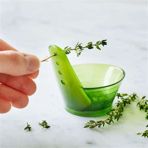 A Person Is Picking Up Some Herbs From A Green Glass Bowl