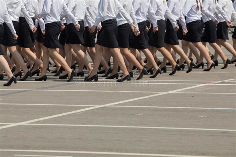 Women In A Uniform Of Police In Black Skirts And White Shirts March A