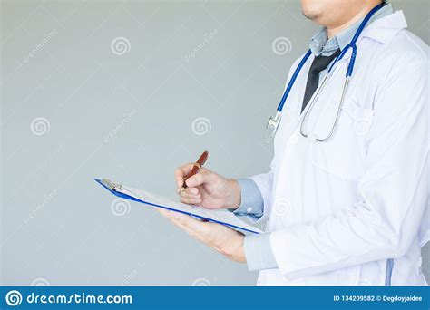Doctor In White Uniform With Stethoscope Holding Pen Writing Report Illness Of Breast Cancer