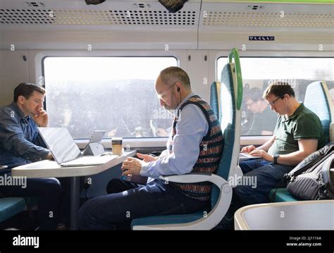 Train Passengers Uk Railway Commuters Working With Computers On The