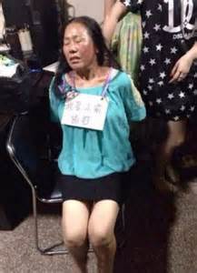 Chinese Shoplifter Made To Sit In Shop Window With Sign Around Her Neck