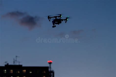 Drone With A Camera Flying Near Building With Windows Stock Photo