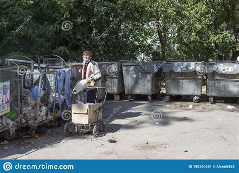 Old Homeless Woman Begging Through The Trash Heaps Standing At The