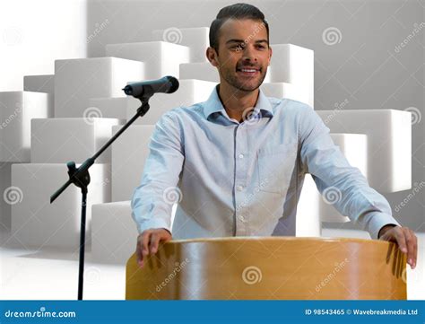Businessman On Podium Speaking At Conference With Cubes Stock Image