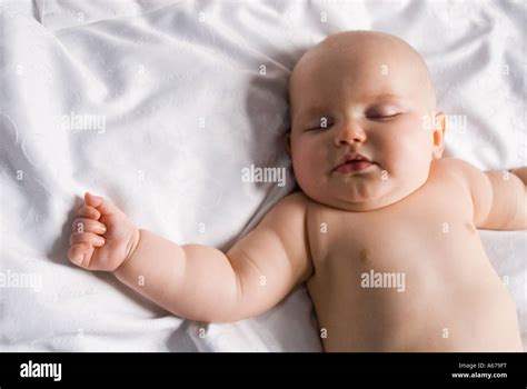 Baby Lying On Its Back Asleep On A Bed Stock Photo Alamy