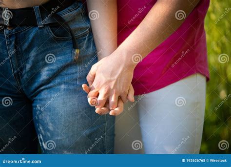 romantic closeup shot of the hands of a couple holding each other longingly and lovingly stock