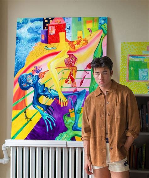 A Man Standing In Front Of A Colorful Painting On The Wall Next To A