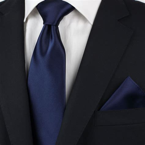 solid dark blue skinny tie paired with a black suit navy blue black suit navy blue suit