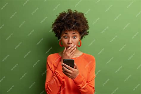 Free Photo Amazed Adult Woman Being Deeply Surprised Stares At Smartphone Display Reads