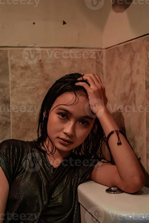 hot and wet asian girl poses with sensual style while wearing black wet dresses 19086696 stock