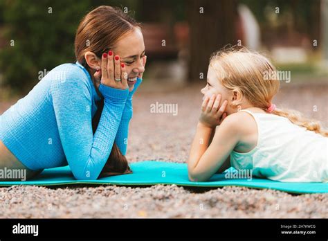 Smiling Mother And Daughter Looking At Each Other While Lying On