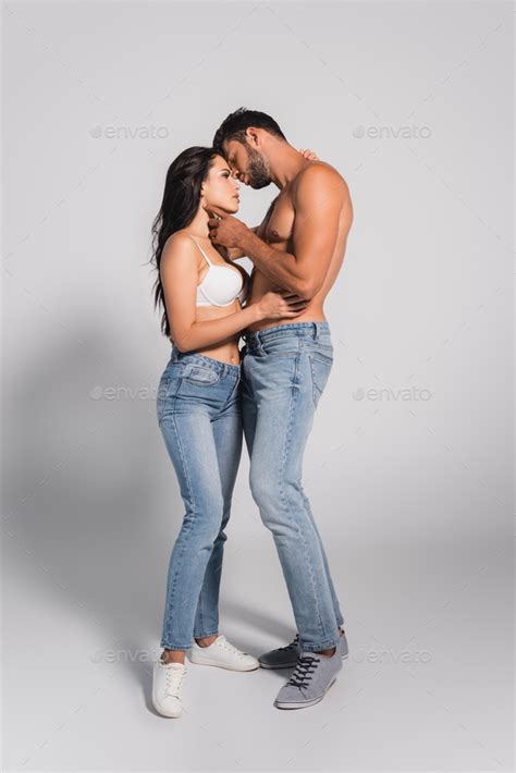 Muscular Man Standing And Touching Seductive Woman In Bra On Grey Stock Photo By Lightfieldstudios