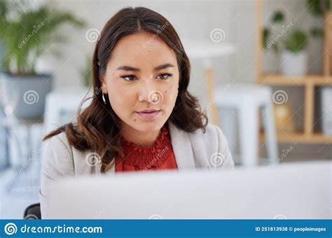 Young Confident Focused Asian Business Woman Sitting Alone In An Office