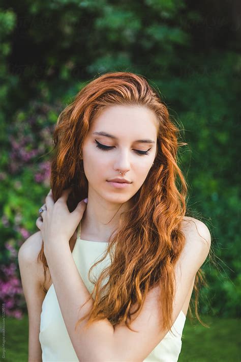 Beautiful Young Redhead Arranging Her Long Hair In A Natural Env By