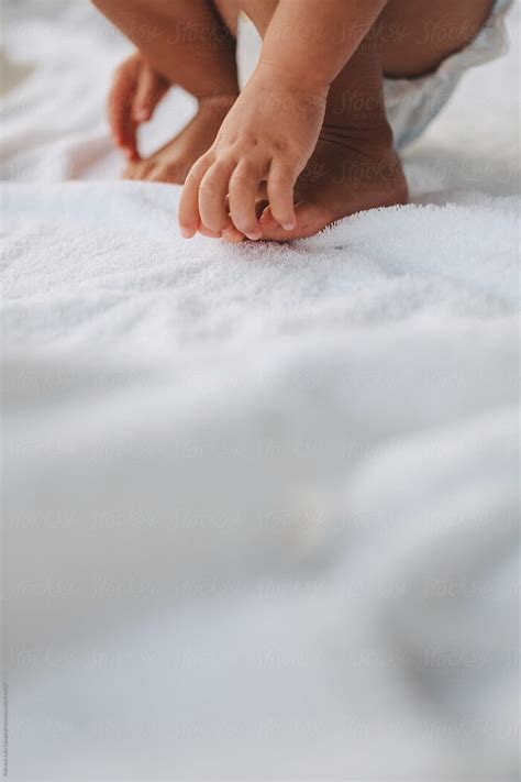 Cute Toddler Boys Hands Touching Feet Outside On Towel By Stocksy