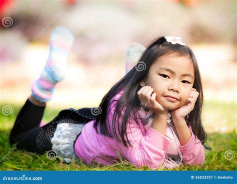 Petite Fille Asiatique Se Reposant Sur L Herbe Verte Image Stock