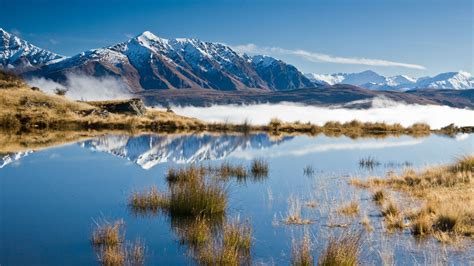 Landscape Mountains With Snow Reflecting Clouds In The Lake Queenstown New Zealand