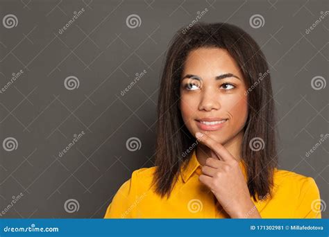 Portrait Of Happy Black Woman Thinking Smiling And Looking Up On Gray
