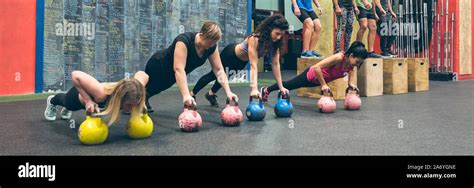 Sportswomen Training With Kettlebells And Sportsmen Doing Box Jumps