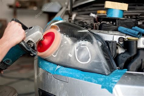 Auto Mechanic Enginner Polishing A Headlight Of A Modern Car With Power