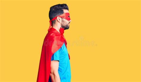 Young Handsome Man With Beard Wearing Super Hero Costume Looking To