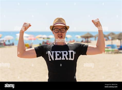 Young Nerd Tourist Man Flexing Both Arms At The Beach Stock Photo Alamy
