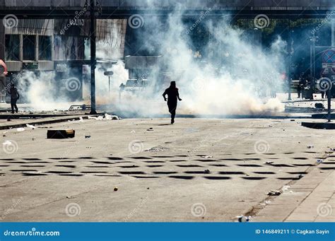 A Protester Trying To Escape From The Tear Gas Fired By The Police