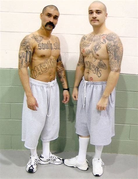 two men with tattoos standing next to each other