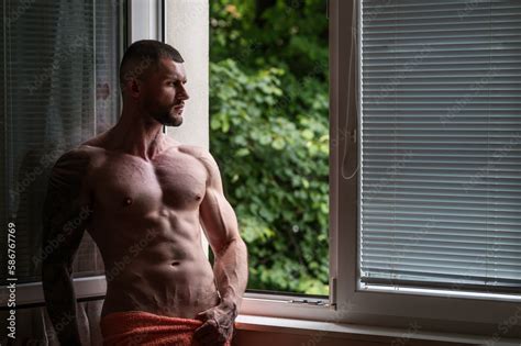man standing near window seductive gay muscular body of man in hotel room sexy guy with naked