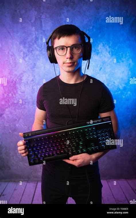 Professional Boy Gamer Holding Gaming Keyboard Over Colorful Pink And