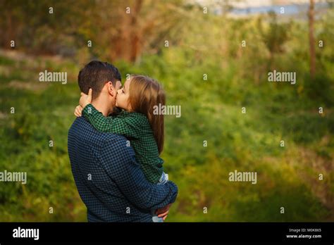 The Father Holds The Daughter In His Arms A Little Daughter Kisses Her