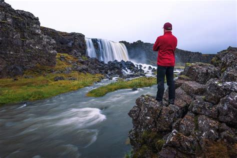 Tourist Looking At The Oxarafoss Waterfall In Iceland Stock Photo