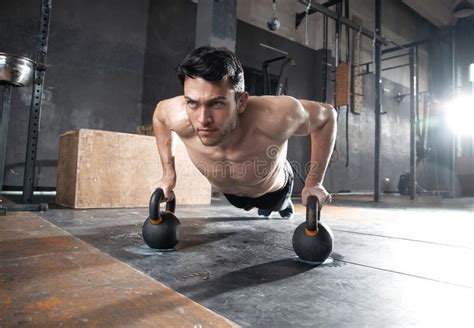 Handsome Muscular Man Doing Pushup Exercise With Dumbbell In A Crossfit