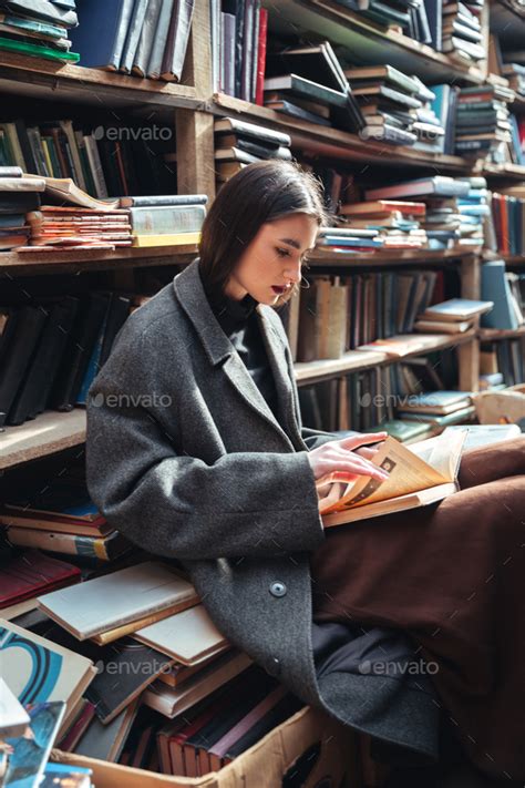 Portrait Of A Woman Reading Book In An Old Library Stock Photo By