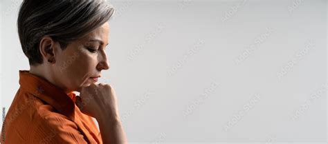 Sad Or Depressed Mature Woman Thoughtfully Touches Her Chin With Hand