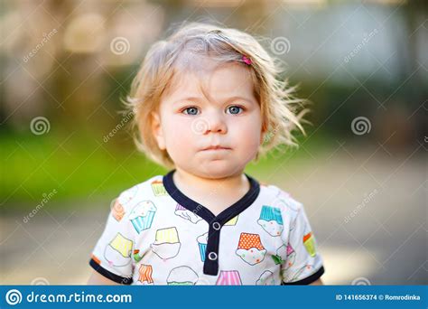 Portrait Of Cute Little Baby Girl In Spring Garden On Sunny Day