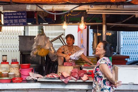 las mujeres están vendiendo la carne en el mercado mojado foto